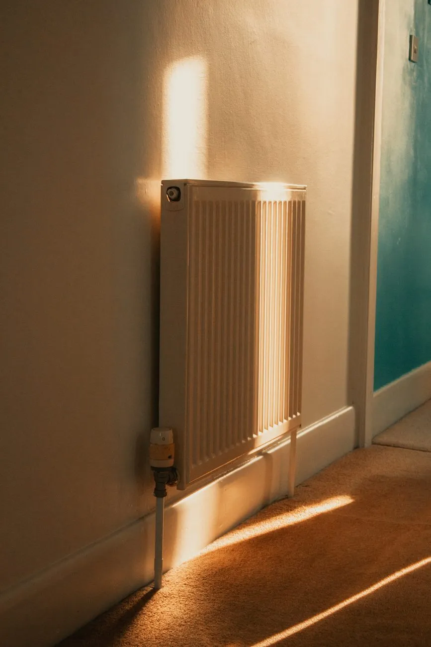 Low sun falling across a hallway radiator and carpet